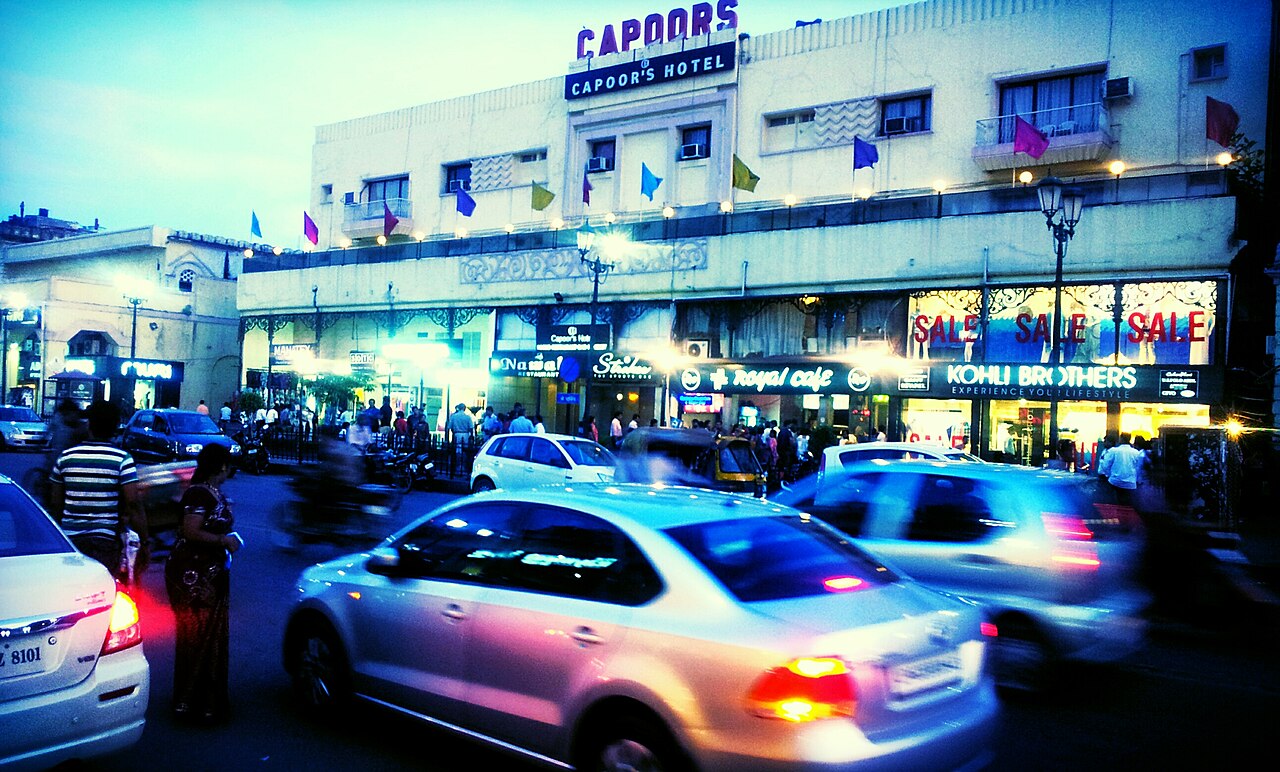 Pedestrians and shops line a street in Lucknow's Hazratganj area.